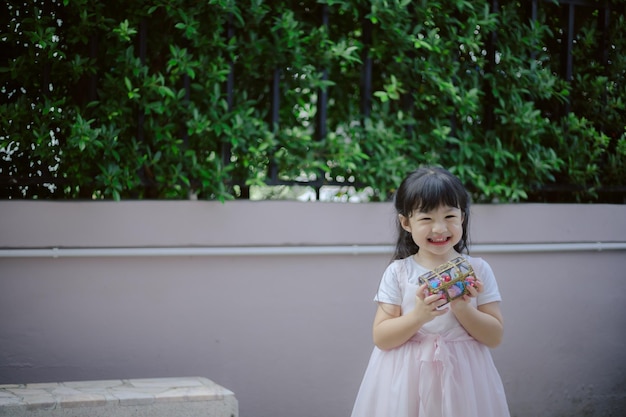 Asiatisches kleines Mädchen, das bunte Schokoladeneier hält