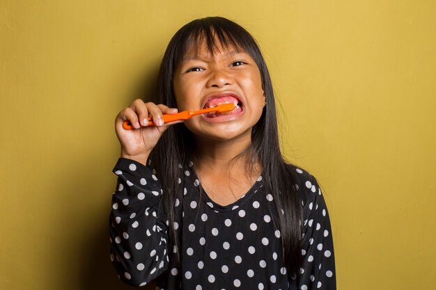 Asiatisches kleines Mädchen, das ihre Zähne putzt