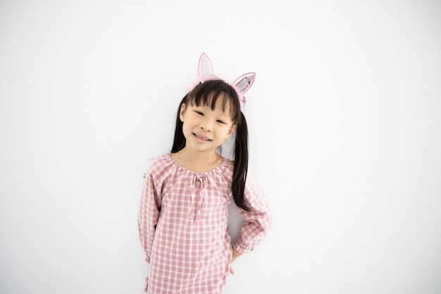Asiatisches kleines Mädchen nett auf weißer Wand