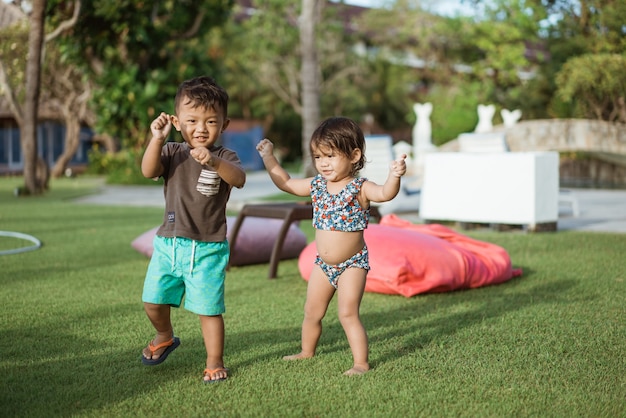 Asiatisches lustiges Kleinkind genießt es, draußen zu tanzen