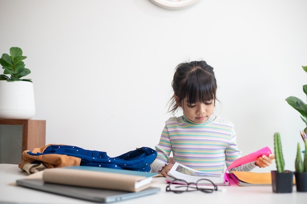 Asiatisches Mädchen, das in der Schule studiert und sehr glücklich aussieht