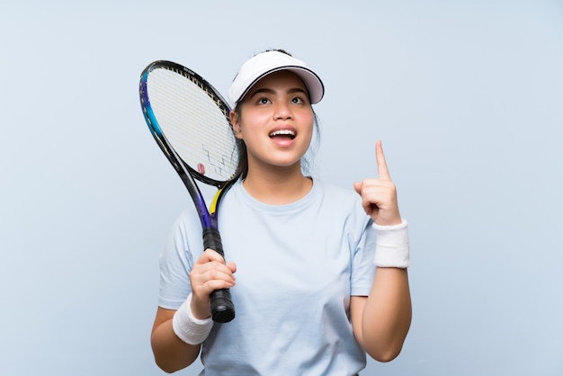 Asiatisches Mädchen des jungen Jugendlichen, das das Tennis beabsichtigt, die Lösung beim Anheben eines Fingers zu verwirklichen spielt