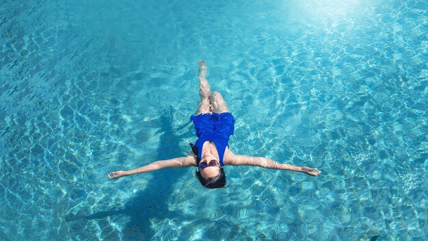 Asiatisches Mädchen entspannt sich beim Schwimmen im Schwimmbad