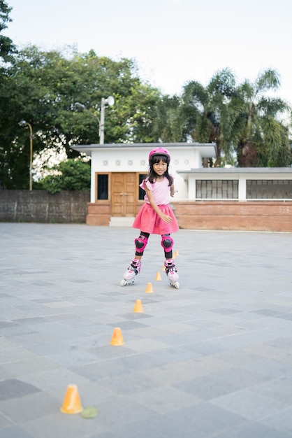 Asiatisches Mädchen geht auf ihre Inline-Skates