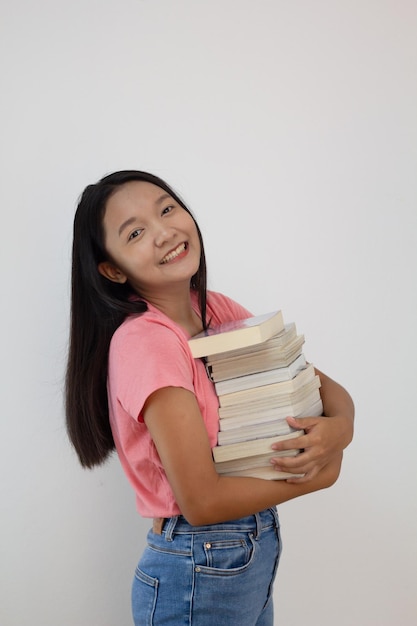 Asiatisches Mädchen hält Buch auf ihrem Arm auf whiye HintergrundStudentin