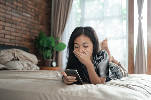 Asiatisches Mädchen im Teenageralter schockiert beim Telefonieren