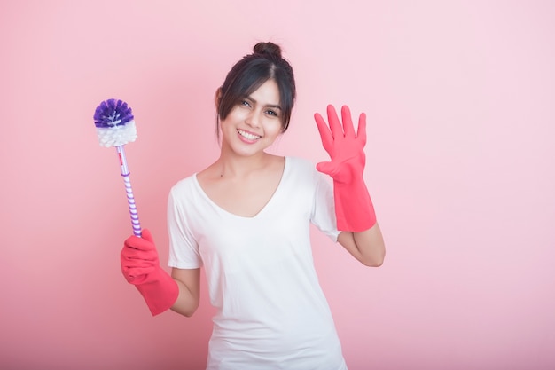 Asiatisches Mädchen mit Reinigungshandschuhen und Toilettenbürste