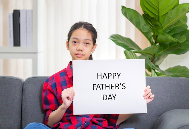 Asiatisches Mädchen mit weißem Blatt Papier Mädchen, das Papier mit der Nachricht Happy Father's Day hält, verspottet ein leeres Zeichen für kreative Designkonzepte der Nachricht