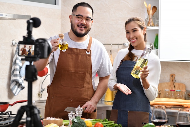 Asiatisches Paar, das ein Video in der Küche aufzeichnet