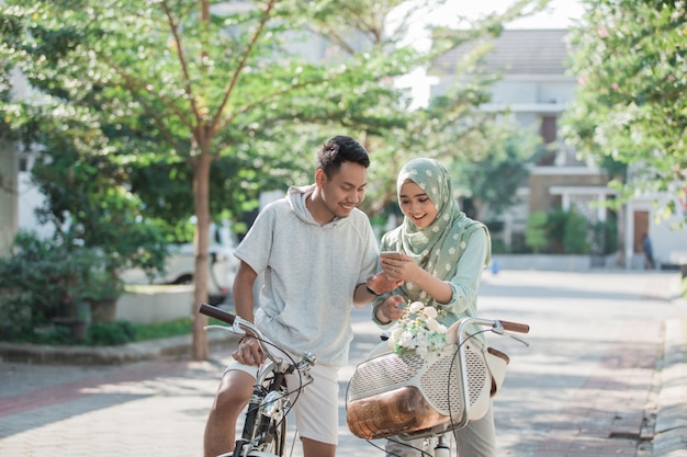 Asiatisches Paar, das Fahrrad fährt