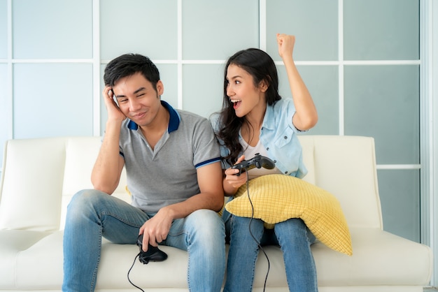 Asiatisches Paar Mann und Frau zum Spielen von Videospielen zu Hause