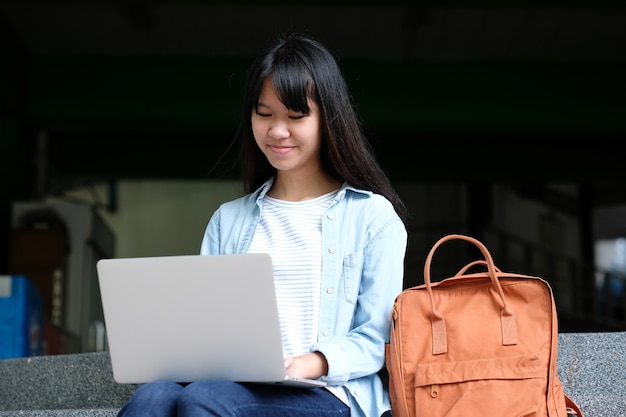 Asiatisches Studentenmädchen, das Laptop-Computer, on-line-Bildung, Konzept des erwachsenen Lernens verwendet