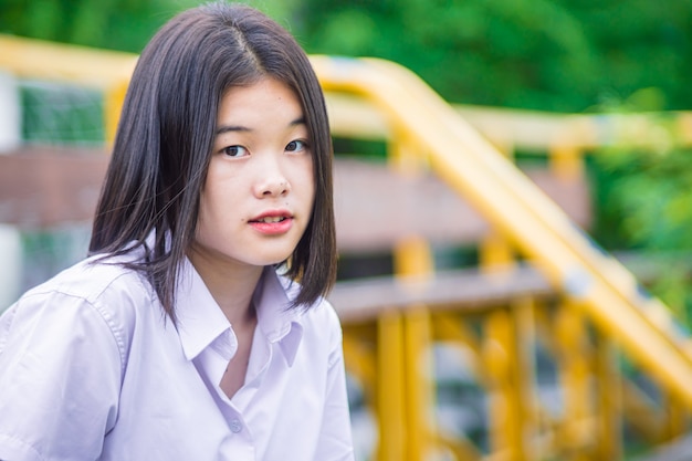 Asiatisches Universitätsstudentenmädchen jugendlich unschuldiger naiver Blick mit Exemplar