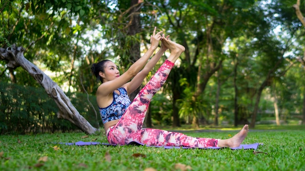 Asien-Frau, die Yoga Haltung an im Freien, Yoga-Übungs-Trainings-Konzept tut