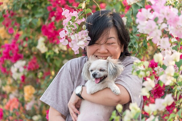 Asien-Frauen und glückliches Lächelnumarmen des Hundes