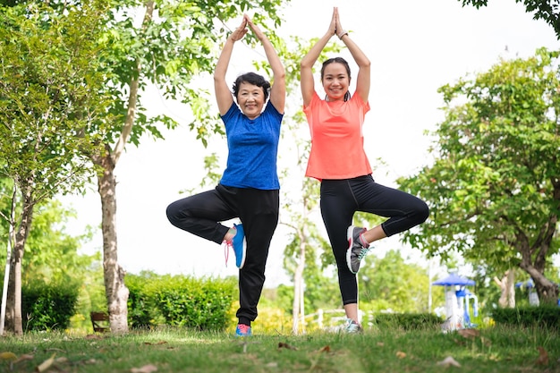 Asien Seniorin und Teenager Frau trainiert Yoga im Garten