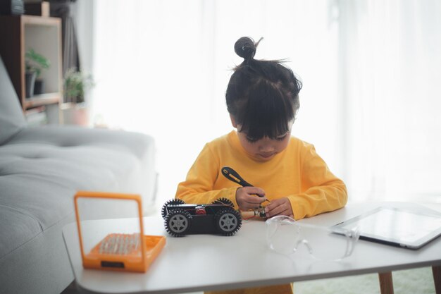 Asien-Studenten lernen zu Hause die Codierung von Roboterautos und Elektronikplatinenkabeln in STEM, STEAM, Mathematik, Ingenieurwissenschaften, Technologie, Computercode im Robotik-Konzept für Kinder.