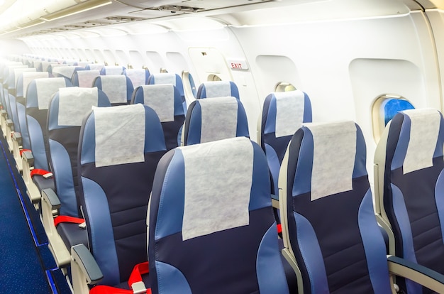 Asiento del pasajero, Interior del avión con pasajeros sentados en los asientos.