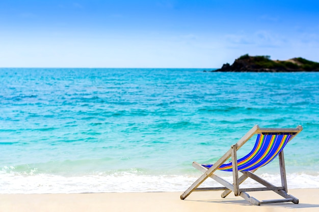 Un asiento en la playa con fondo azul del mar