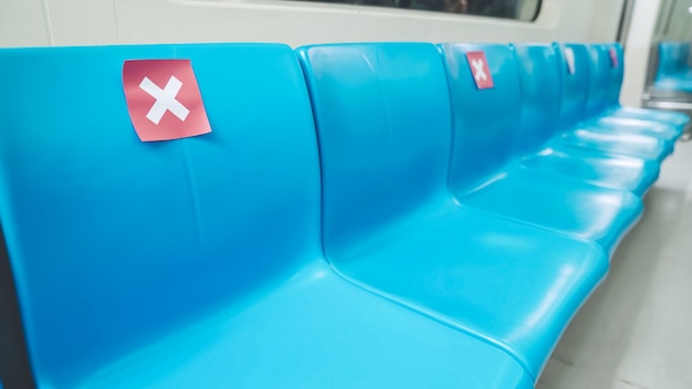 Asiento en público en metro público subterráneo con letreros de distanciamiento social