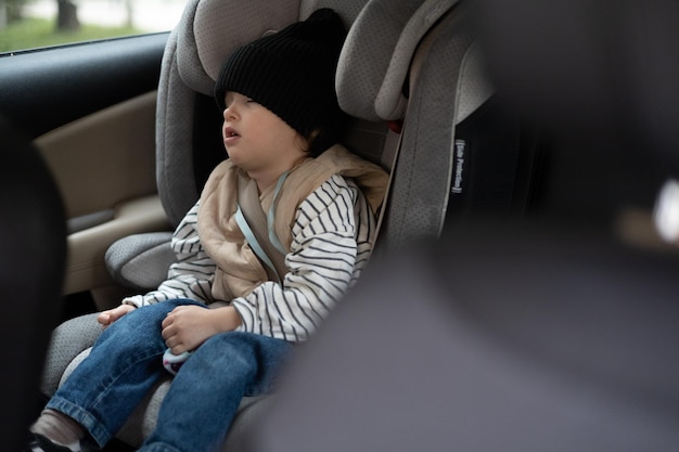 Asiento de seguridad para niños y comodidad de transportar niños en un automóvil Retrato de un niño pequeño que se durmió en un asiento de automóvil