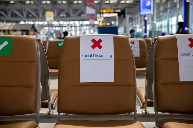 Asientos en el aeropuerto con letreros de distancia social