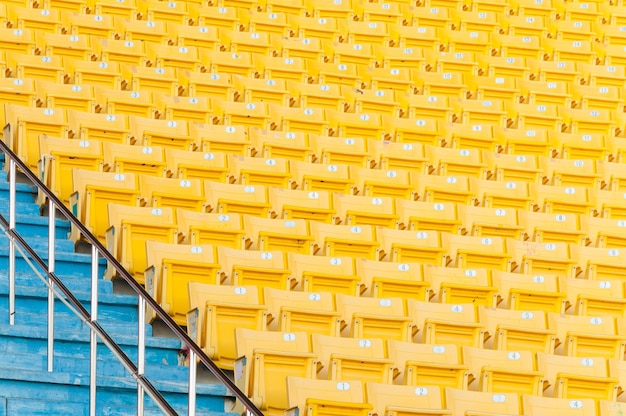 Asientos amarillos vacíos en el estadioFilas de asientos en un estadio de fútbolseleccione el enfoque