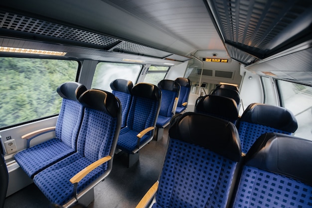 Foto asientos azules cómodos y hermosos en el tren. transporte. viajes.