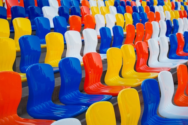 Asientos de plástico coloridos vacíos en el estadio de fútbol