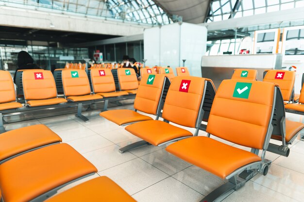 Los asientos públicos de color naranja en el aeropuerto están espaciados dentro de la terminal del aeropuerto