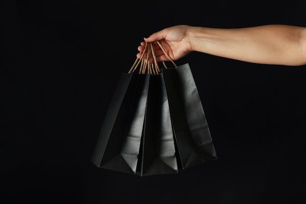 Asimiento de la mano femenina bolsas de papel en negro