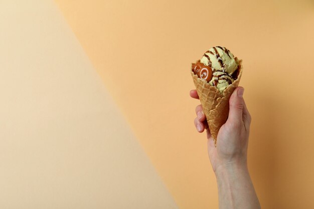 Asimiento de la mano femenina helado de caramelo en dos tonos