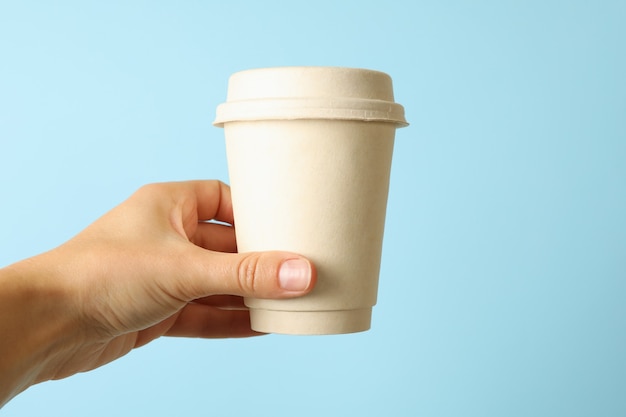 Asimiento de la mano femenina taza de café en azul