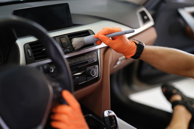 Foto asimiento de la mano masculina rubor gris en guantes protectores naranjas