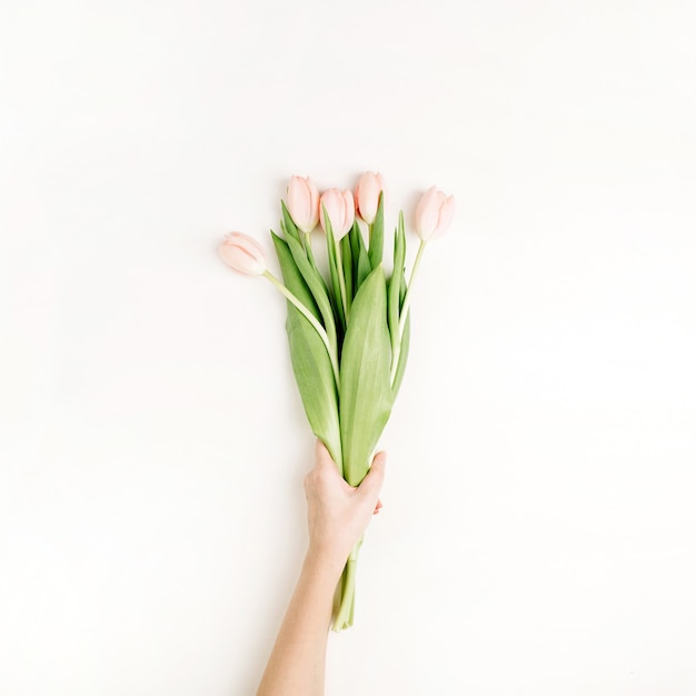 Asimiento de la mano de mujer ramo de flores de tulipán rosa