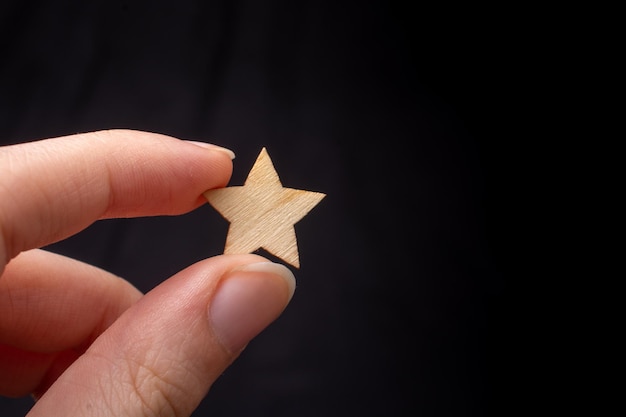 Asimiento de la mano signo de estrella de madera Concepto de evaluación del servicio del producto