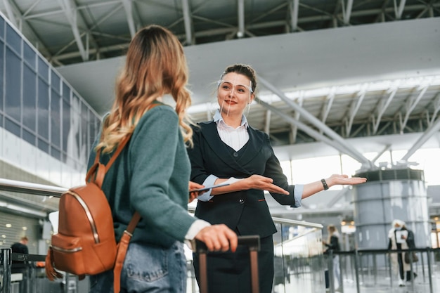 Asistencia de mujer en ropa formal Joven turista está en el aeropuerto durante el día