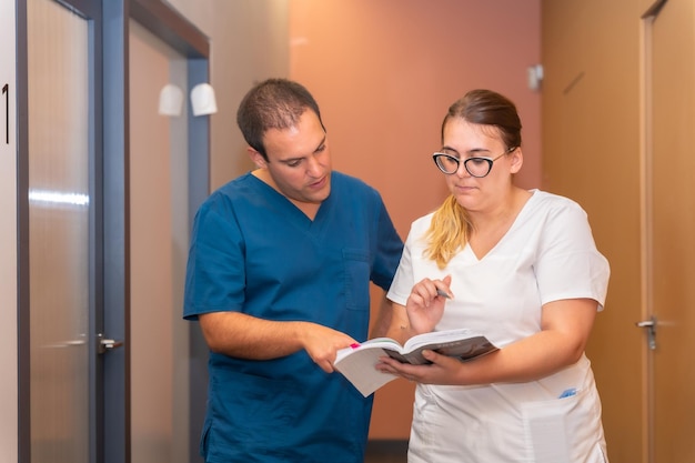 Asistente de clínica dental mirando con el médico dental la agenda del cliente