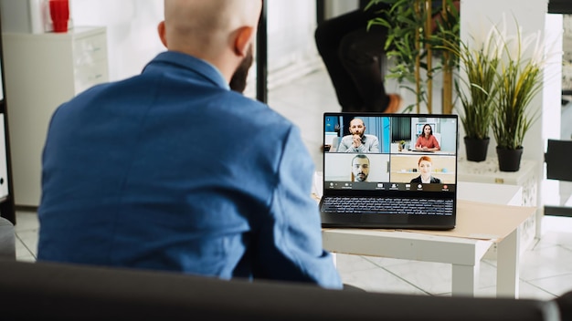 Asistente ejecutivo hablando en una reunión informativa por videollamada con colegas, compartiendo una nueva visión de desarrollo empresarial en una llamada de teletrabajo. Empleado discutiendo con personas en videoconferencia en línea.