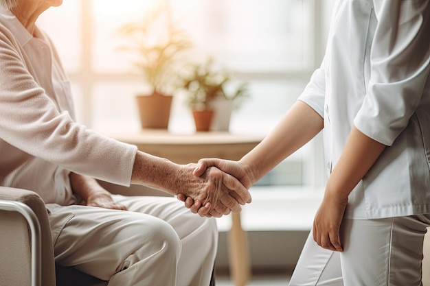 La asistente femenina le da la mano a una anciana para ayudarla