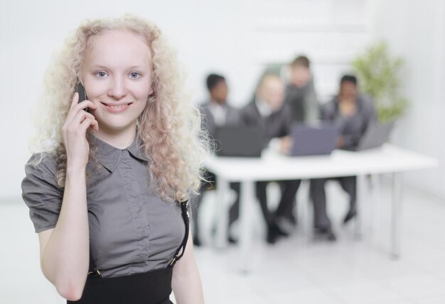 Asistente femenina hablando por teléfono móvil en la oficina