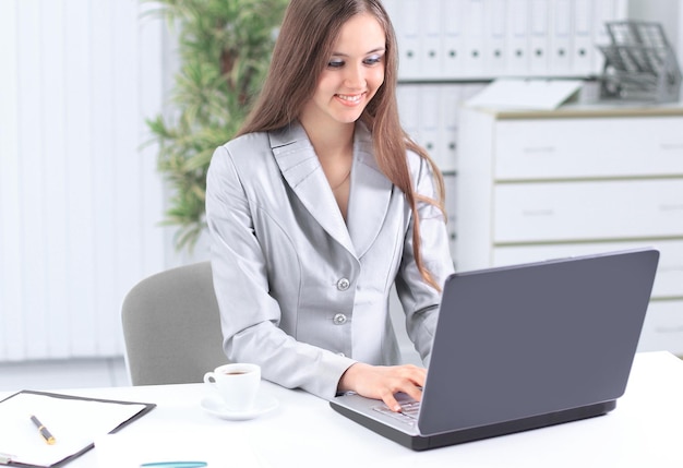 Foto asistente femenina sentada en su escritorio en la oficina