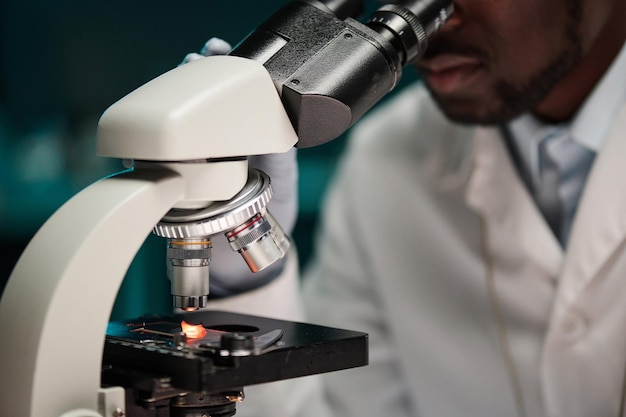 Asistente de laboratorio mirando un pedazo de carne sintética a través del microscopio