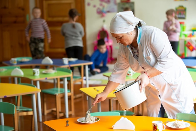 Asistente de maestra en jardín de infantes Niñera en un grupo de niños.