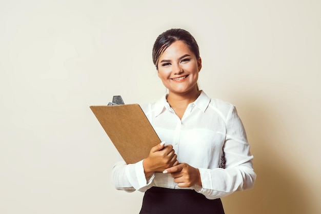 Asistente de mujer latinx sosteniendo un portapapeles para el concepto de reclutador de entrevistas de trabajo