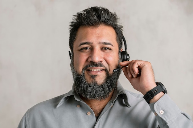 Asistente de operador indio usando un auricular de micrófono mientras conversa con un cliente