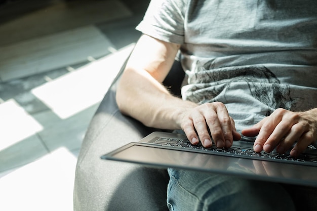 Foto asistente virtual trabajo independiente trabajo remoto para ganar dinero en línea espacio de trabajo cómodo en casa hombre relajado escribiendo en la computadora portátil