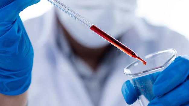 Los asistentes de laboratorio están investigando reacciones químicas, científicos médicos, investigadores químicos, experimentos químicos y pruebas de enfermedades a partir de muestras de sangre de pacientes, concepto de medicina e investigación.