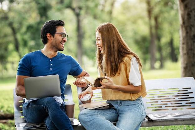 Asociación Estudiante Amigo sosteniendo Paraguas y estudio de trabajo con el apoyo de Socios juntos en Park Business Pareja joven Socio Discutir al aire libre Colegas de negocios Fuera de la oficina Una pareja