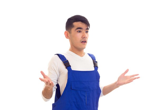 Asombrado joven con cabello oscuro vestido con camisa blanca y azul en general mirando a la distancia